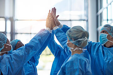 Ein Team aus dem Funktionsdienst schlägt die Hände zusammen